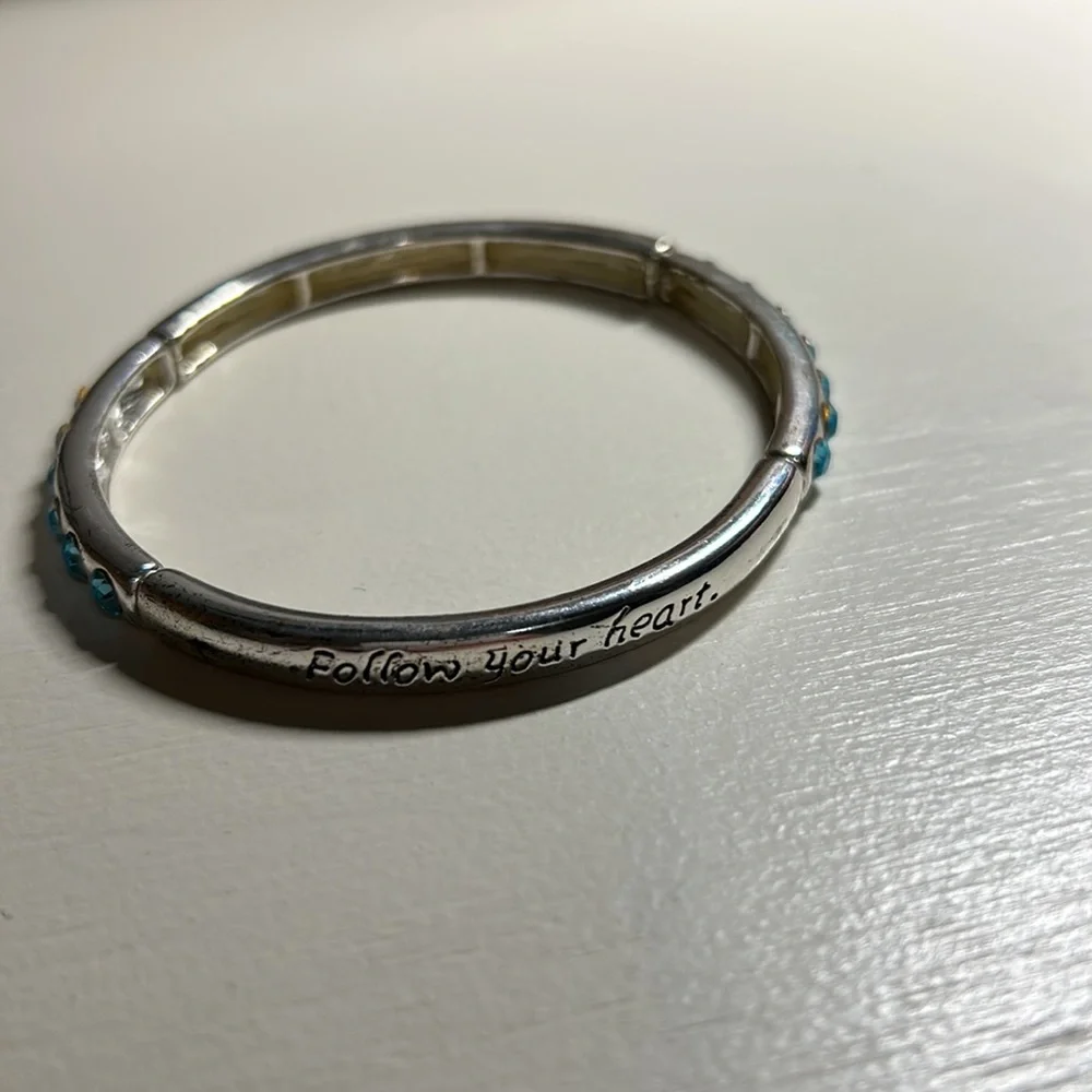 Kids silver bracelet with 7 blue rhinestones each side of bracelet. Gently used